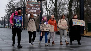 Kharkiv, Ukrayna - Mart, 08, 2023: Kızlar ve bir erkek şehir meydanında cinsiyet ayrımcılığına, ataerkilliğe ve yazıtlara karşı posterlerle yürüyorlar.