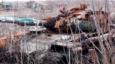Rusya sınırı yakınlarındaki bir Ukrayna köyünde, paslı bir tareti olan yıkılmış bir tank uzun ve kuru çimlerde duruyor. Rus-Ukrayna Savaşı 2022-2023
