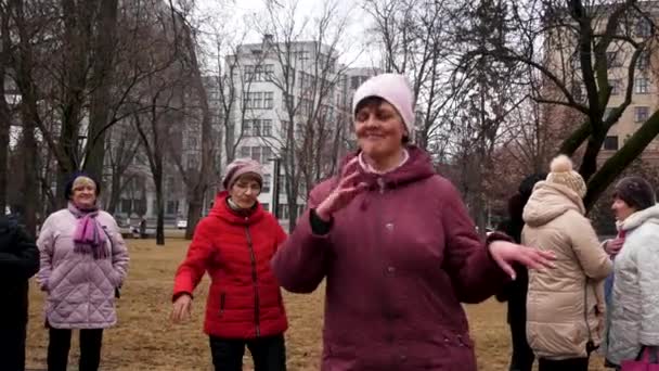 ウクライナのハリコフ 2023年3月8日 笑顔の年上の女性が笑顔で 他の高齢者や男性と一緒に都市公園で美しく踊ります 幸せな高齢者 完全な生活 リラクゼーションと — ストック動画