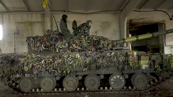 ウクライナの旗を持つタンク 迷彩ネットでは 装甲上のタンカーは戦闘任務のために出発する前に具体的な格納庫に立っています ロシア ウクライナ戦争2022年 2023年 ウクライナ — ストック動画