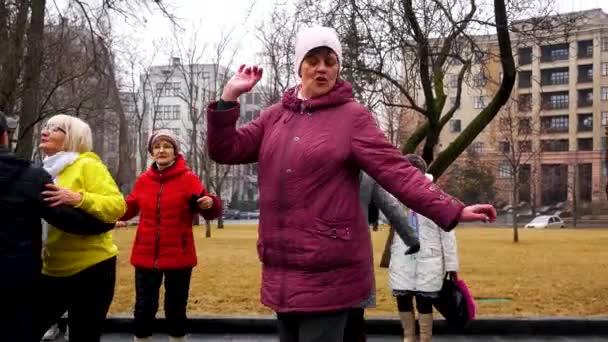 ウクライナのハリコフ 2023年3月8日 笑顔の年上の女性が笑顔で 他の高齢者や男性と一緒に都市公園で美しく踊ります 幸せな高齢者 完全な生活 リラクゼーションと — ストック動画