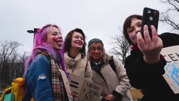 ウクライナのハリコフ 2023年3月8日 彼らの顔や性差別に対するポスターに描かれた性別の兆候を持つ女の子は誇りの間に自撮りします ジェンダーに基づく暴力と性差別との闘い — ストック動画