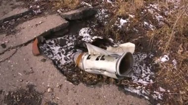 Bir roket topçu mermisi asfaltı deldi ve yerden çubuklar çıkardı. Ukrayna şehrinin bombalanmasının sonuçları. Rus-Ukrayna savaşı 2022-2023. Şehirlerin topçu bombardımanı