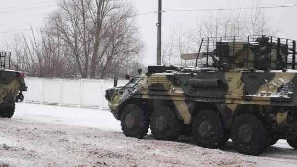ウクライナのハリコフ 2022年1月31日 多くの装甲兵員輸送車が道路上の船団の中で出発する 側面には軍用ユニットのコンクリート壁があります ロシア ウクライナ戦争 重い物の運搬 — ストック動画