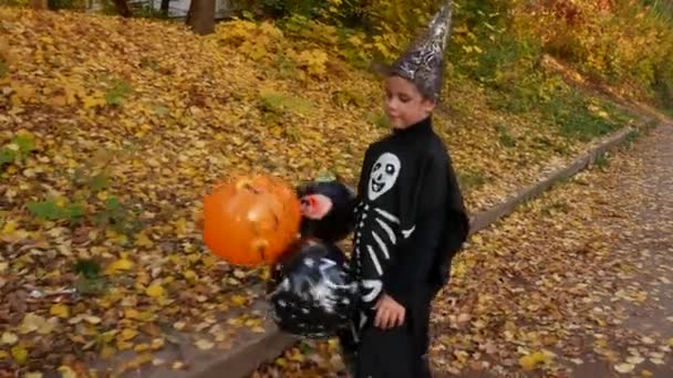 Siyah Takım Elbiseli Boyalı Iskeletli Şapkalı Bir Çocuk Sonbahar Parkında — Stok video