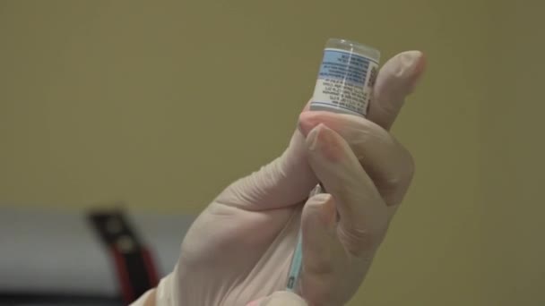 ハリコフ ウクライナ 2021年10月29日 白い手袋の医師の手は バイアルから注射器でワクチンを収集します Covid 19パンデミック時の大量予防接種 — ストック動画
