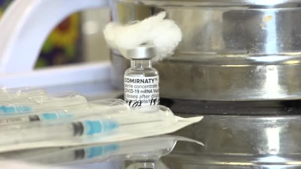 病院のテーブルの上にCovid 19ワクチン 注射器 綿毛とバイアル コロナウイルスのパンデミック時の大量予防接種 — ストック動画
