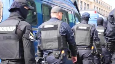Kharkiv, Ukrayna - 6 Eylül 2021: Zırhlı birçok polis memuru cadde boyunca yürüyor, polis arabaları yakınlarda dolaşıyor. Toplu ayaklanmalar