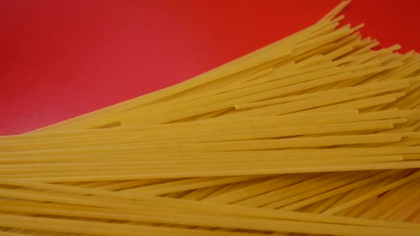 赤い背景に長い生パスタ パスタ スパゲティ — ストック動画