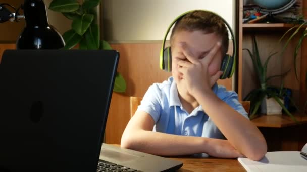 一个男孩厌倦了在笔记本电脑显示器前学习 用手捂住脸 用手指揉揉眼睛 远程学习 — 图库视频影像