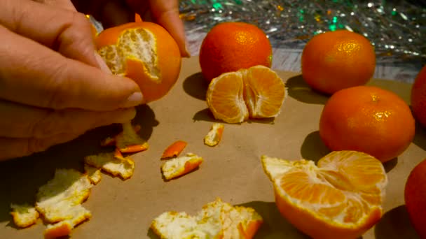Mãos Das Mulheres Descascam Tangerina Quebram Fruta Luzes Festivas Fundo — Vídeo de Stock