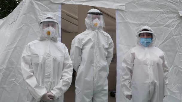 2021年6月12日 乌克兰哈尔科夫 三名身穿Covid防护服 面罩和透明面罩的医生站在一家野战医院外面 — 图库视频影像