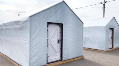 Mülteciler için modüler bir kasabanın beyaz çadırları ve evsiz bırakılan insanlar. Rus-Ukrayna Savaşı 2022-2023