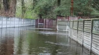Köyde su basmış cadde. Uzakta, bir adam su basmış bir caddede kayıkla yüzüyor. Bahar seli, doğal afet