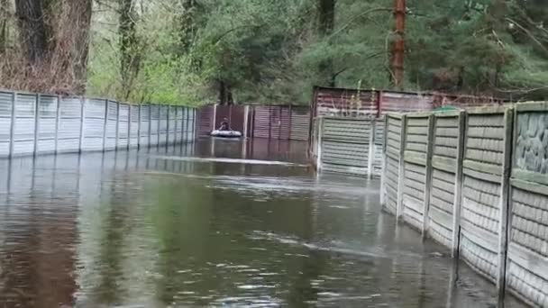 村里被洪水淹没的街道 在远处 一个人在一条被水淹没的街道上漂流着 春天的洪水 自然灾害 — 图库视频影像