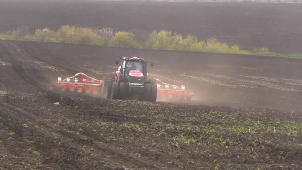 Ein Traktor Mit Sämaschine Fährt Durch Ein Gepflügtes Feld Mit — Stockvideo