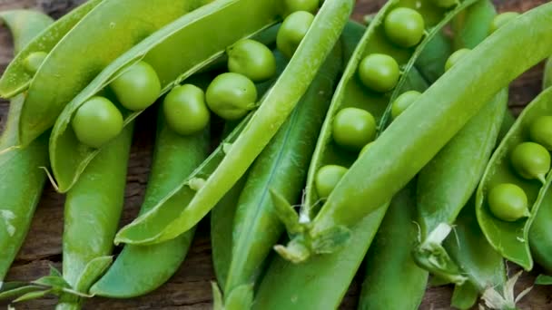 木制表面上开着绿色的新鲜豌豆 新鲜采摘的豌豆 维生素 高蛋白植物类食物 — 图库视频影像