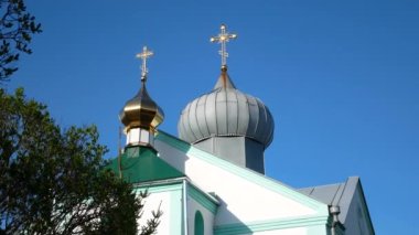 Üzerinde altın, gri kubbeler ve mavi gökyüzüne karşı parlak altın haçlar olan bir Ortodoks kilisesi. Ortodoksluk. Ukrayna 'daki Moskova Patrikliği Kilisesi. Ortodoks bayramı