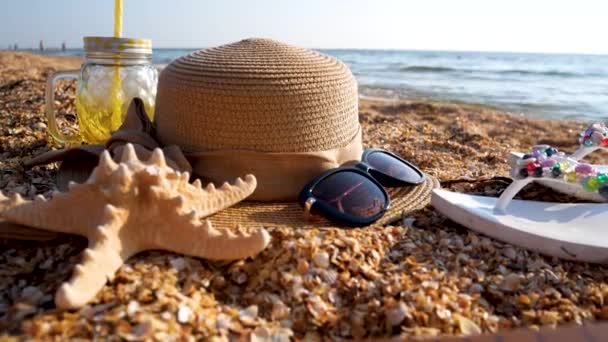 Hat Sunglasses Flip Flops Cocktail Jar Starfish Sandy Beach Sea — Stock Video