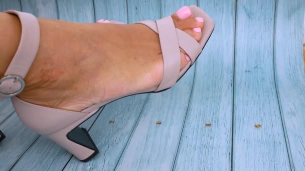 ヒールの高い美しいライトヌードカラーのサンダルで女性の足 女の子はファッショナブルな靴を賞賛し 彼女の足を振る ファッションとスタイル — ストック動画