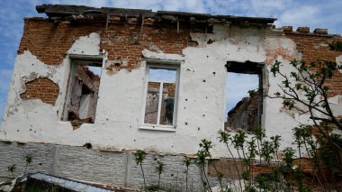 Ukrayna 'daki bir köyde Rus topçu ateşi sonucu yıkılmış bir yerleşim yeri. Evin penceresi ve çatısı yok. Russo-Ukrayna Savaşı