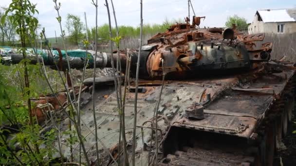 破壊され焼かれた錆びたタンクが茂みの中に立っています 戦車の銃口は道路に向けられている ロシア ウクライナ戦争2022 2023 — ストック動画