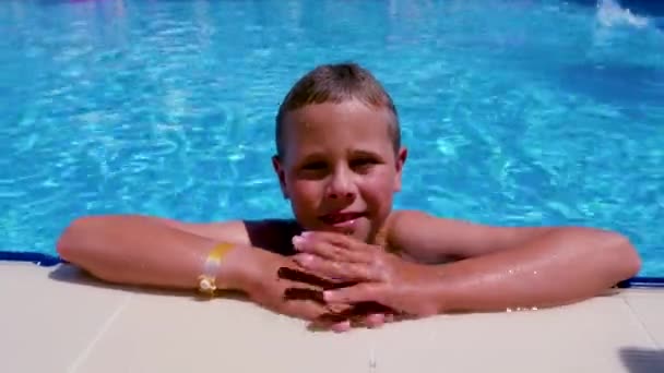 夏にはホテルのプールの横でかわいい幸せな笑顔の男の子 夏休み休暇 — ストック動画