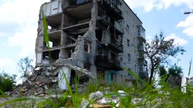 Ukrayna 'nın bir şehrinde hava saldırısıyla yıkılan çok katlı bir bina. Evin girişi tahrip edilmiş, duvarları olmayan bir levye, duvarlarda ateş izleri. Russo-Ukrayna Savaşı