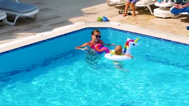 トルコ側 2023年6月18日 ユニコーンバスの形をしたインフレータブルサークルの子供を持つ母親がプールで泳いでいます 水の活動 夏休み — ストック動画