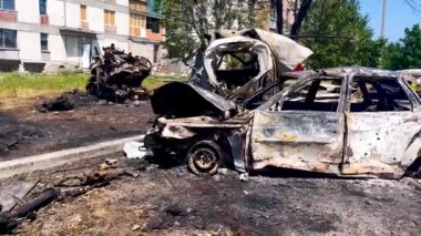 Burned-out cars at the site of the missile strike. In the background are residential buildings with broken windows. Russian-Ukrainian War 2022-2023. Missile attack on residential buildings in