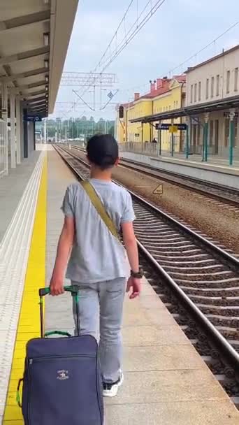 Хлопчик Несе Валізу Залізничній Платформі Вокзалі Боці Розташовані Рейки Залізничної — стокове відео