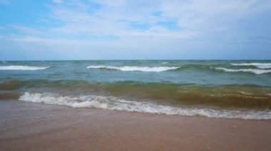 Sörf dalgaları ve kumlu plaj. Yaz tatili konsepti, sıcak ülkelere seyahat. Denizin kıyısındaki ıssız kumsalda meditasyon ve rahatlama