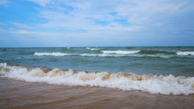 Sörf dalgaları ve kumlu plaj. Yaz tatili konsepti, sıcak ülkelere seyahat. Denizin kıyısındaki ıssız kumsalda meditasyon ve rahatlama