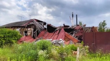 Ukrayna 'nın bir köyünde top mermisi ile yıkılan bir ev. Yıkık çatılı bir ev, molozların altından bacalar görünüyor. Rus-Ukrayna savaşı, gerçek savaş.