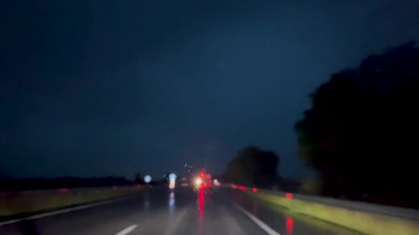 雨が道の真上に降っている 移動する車の窓からの眺め — ストック動画