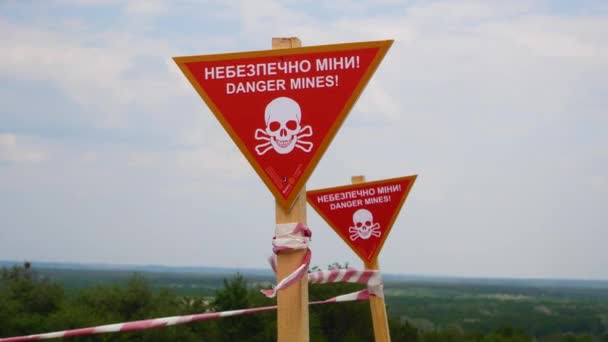 入植地の前に警告碑付きのサイン フェンシングテープ ウクライナの村の鉱山地帯 ロシア ウクライナ戦争2022 2023年 人道的弱体化の概念 — ストック動画