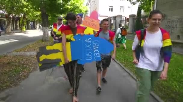 ウクライナのハリコフ 2月2023日 虹の花瓶の女の子と男は 碑文の地下セクシズムを持つ男性の段ボール図を運びます Lgbtの権利について プライド 合法化するための要件 — ストック動画
