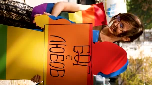 乌克兰哈尔科夫 2023年9月2日 一个穿着彩虹衣服的女孩拿着一个印有上帝之爱字样的男人的纸板 Lgbt群体争取平等权利的斗争 为之奋斗 — 图库视频影像