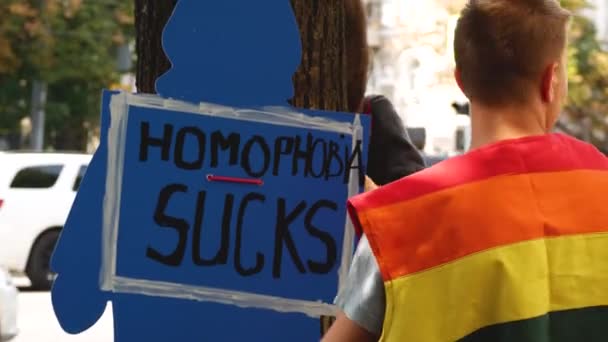 乌克兰哈尔科夫 2023年9月2日 一个穿着彩虹衣服的人拿着印有Homofobia Sucs字样的纸板 男女同性恋 双性恋和变性者群体争取使其合法化的斗争 — 图库视频影像