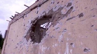 Topçu mermisi tarafından vurulduktan sonra evin duvarında bir delik. Savaş sırasında sivil evlerin tahrip edilmesi. Rus-Ukrayna savaşı.