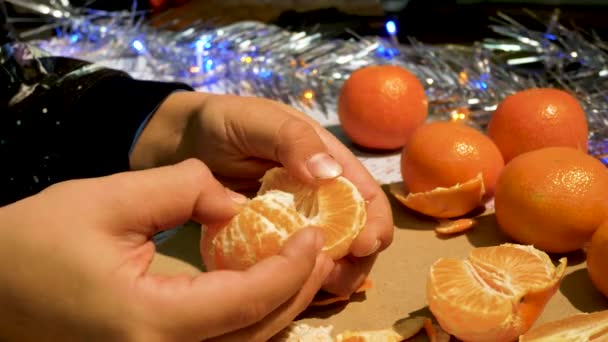 Mâinile Copiilor Curăță Tangerină Suculentă Rup Felii Lumini Crăciun Fundal — Videoclip de stoc