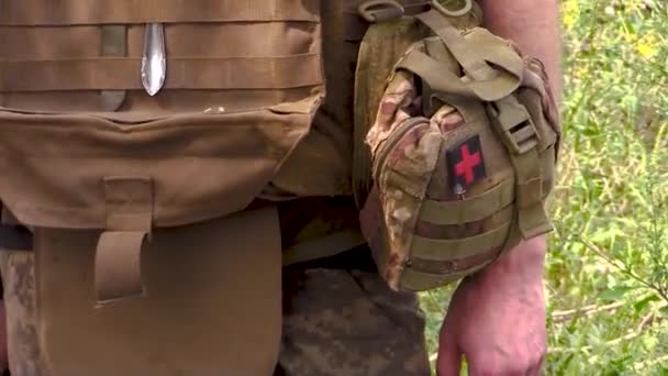 一名身穿军服的士兵 身穿防弹背心 制服上附有急救箱 军事设备 后续行动 — 图库视频影像