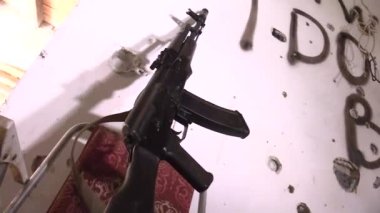 Saldırı tüfeği binanın duvarına dayalı. Duvarda savaştığım bir yazıt var. Avcılar için bir pusu. Gerçek bir savaşın yeri. Savaş.