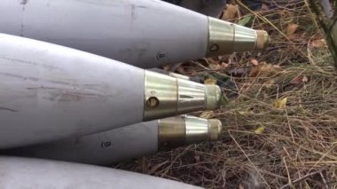 Toplardaki tanklar için bir sürü kovan kuru çimlerin üzerinde yatıyor. Savaş için hazırlık. Gerçek bir savaş. Rus-Ukrayna savaşı.