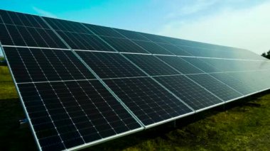Yerdeki büyük güneş panelleri mavi gökyüzüne karşı. Güneşten gelen elektrik üretimi. Yeşil enerji kavramı.