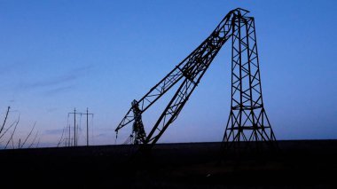 Yüksek voltajlı bir elektrik hattının yıkılmış kulesi. Enerji Güvenlik Konsepti. Elektrik üretimi ve taşımacılığı.