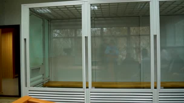 一个装有防弹玻璃的空笼子 关押在法庭上的嫌疑犯 人们正在等待审判 — 图库视频影像