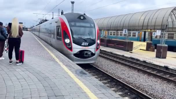 ウクライナのハリコフ 2023年11月18日 都市間の旅客列車が人々が立っているプラットフォームに引き上げられます 鉄道輸送について 電車で旅行する 高速列車 — ストック動画
