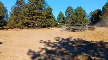 Ukrayna bayrağı taşıyan bir tank kumlu orman yolunda ilerliyor. Savaş tatbikatları. Rus-Ukrayna savaşı.