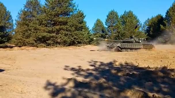 一辆悬挂乌克兰国旗的坦克正沿着一条沙地森林公路行驶 战斗演习 俄乌战争 — 图库视频影像
